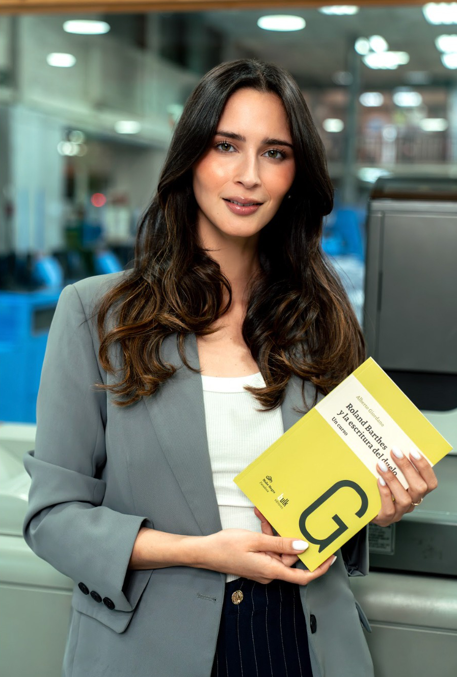 Cliente sostiene un libro terminado en la planta de Grafhika